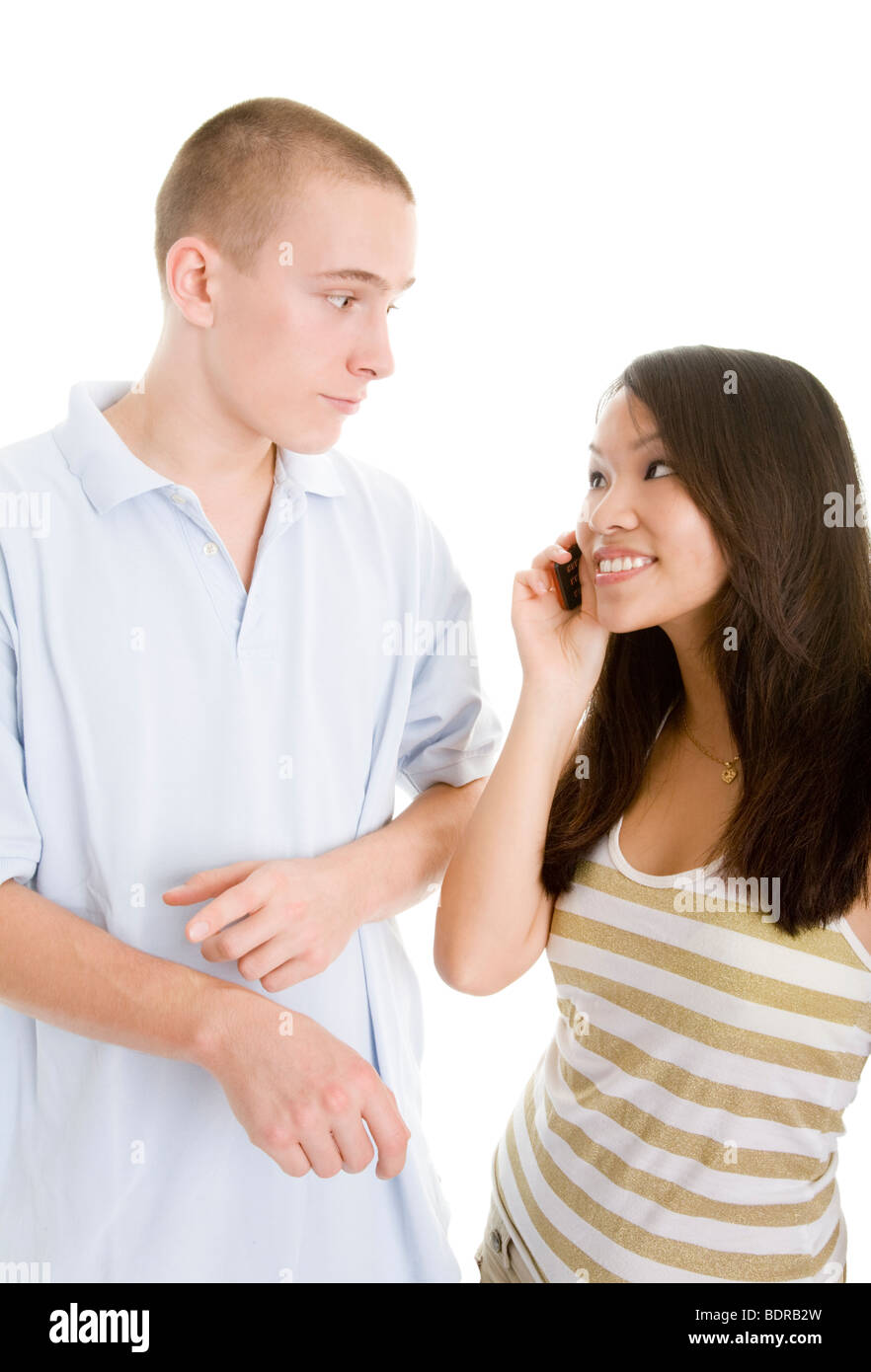 Junger Mann dr ngt seine telefonierende Freundin durch das Zeigen auf eine imagin re Armbanduhr zum Aufbruch Stock Photo