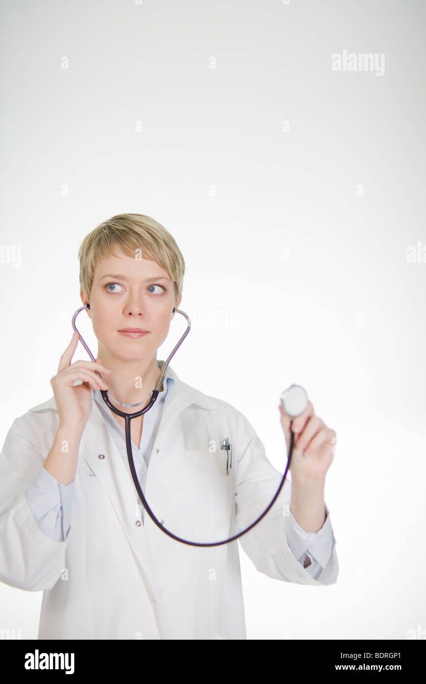 A female doctor listening into a stethoscope Stock Photo - Alamy