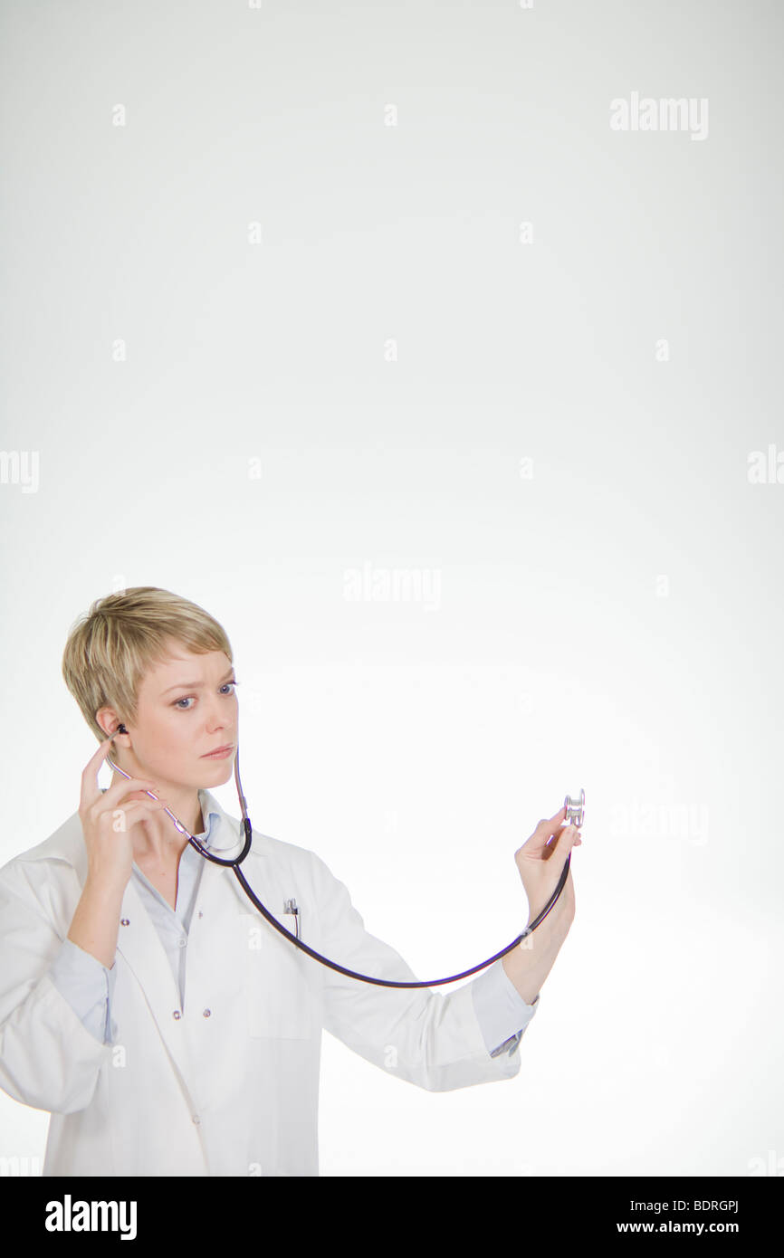 A female doctor listening into a stethoscope Stock Photo - Alamy