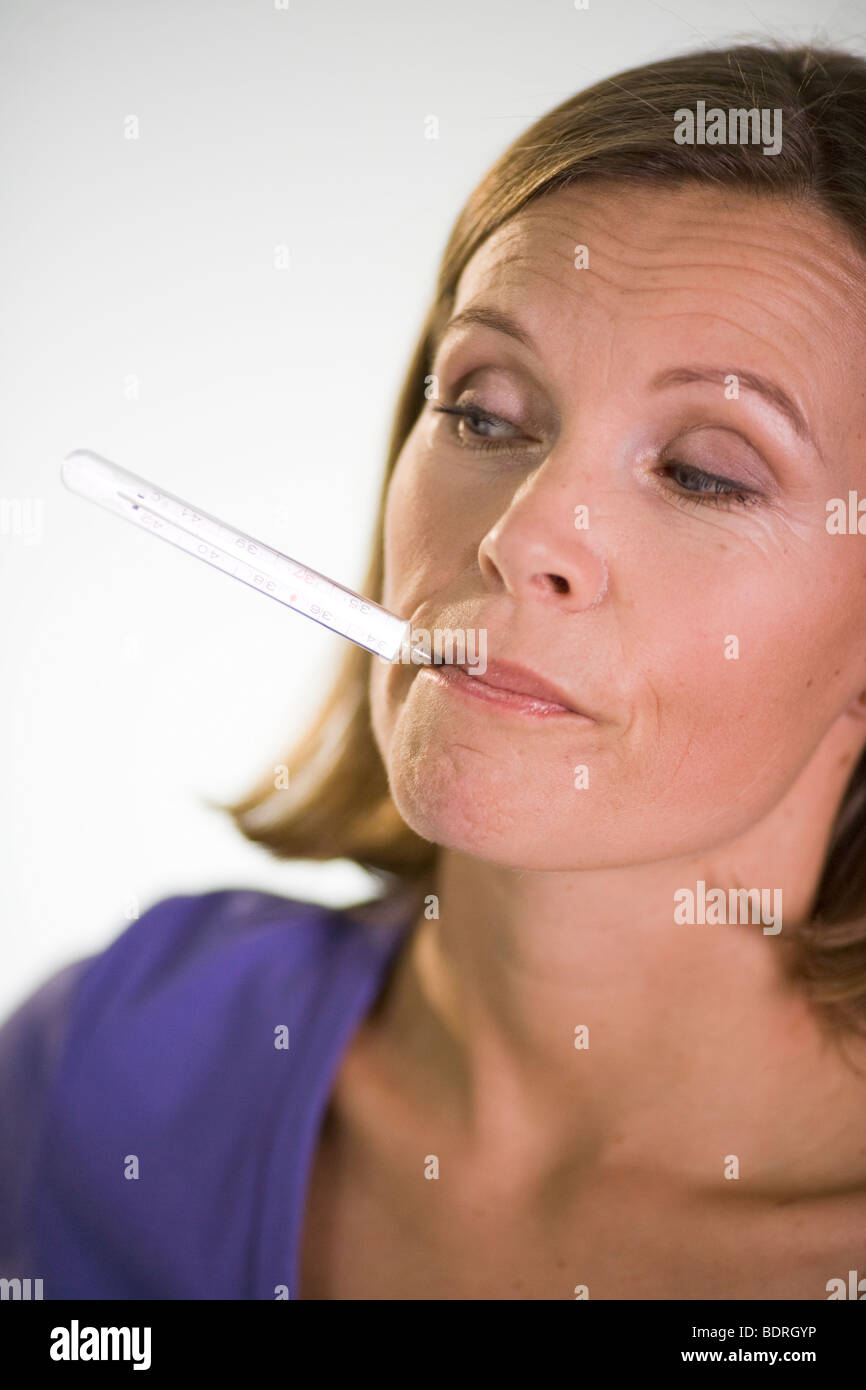 A woman taking her temperature. Stock Photo