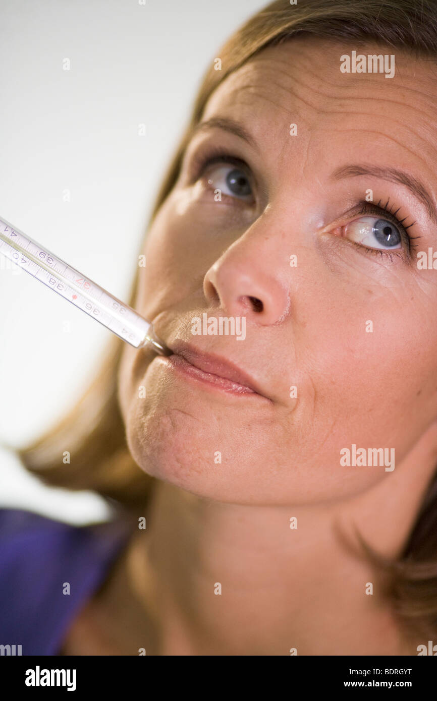 A woman taking her temperature. Stock Photo
