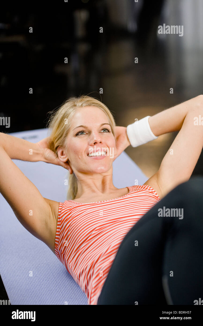 A woman doing sit-ups at a gym Stock Photo - Alamy