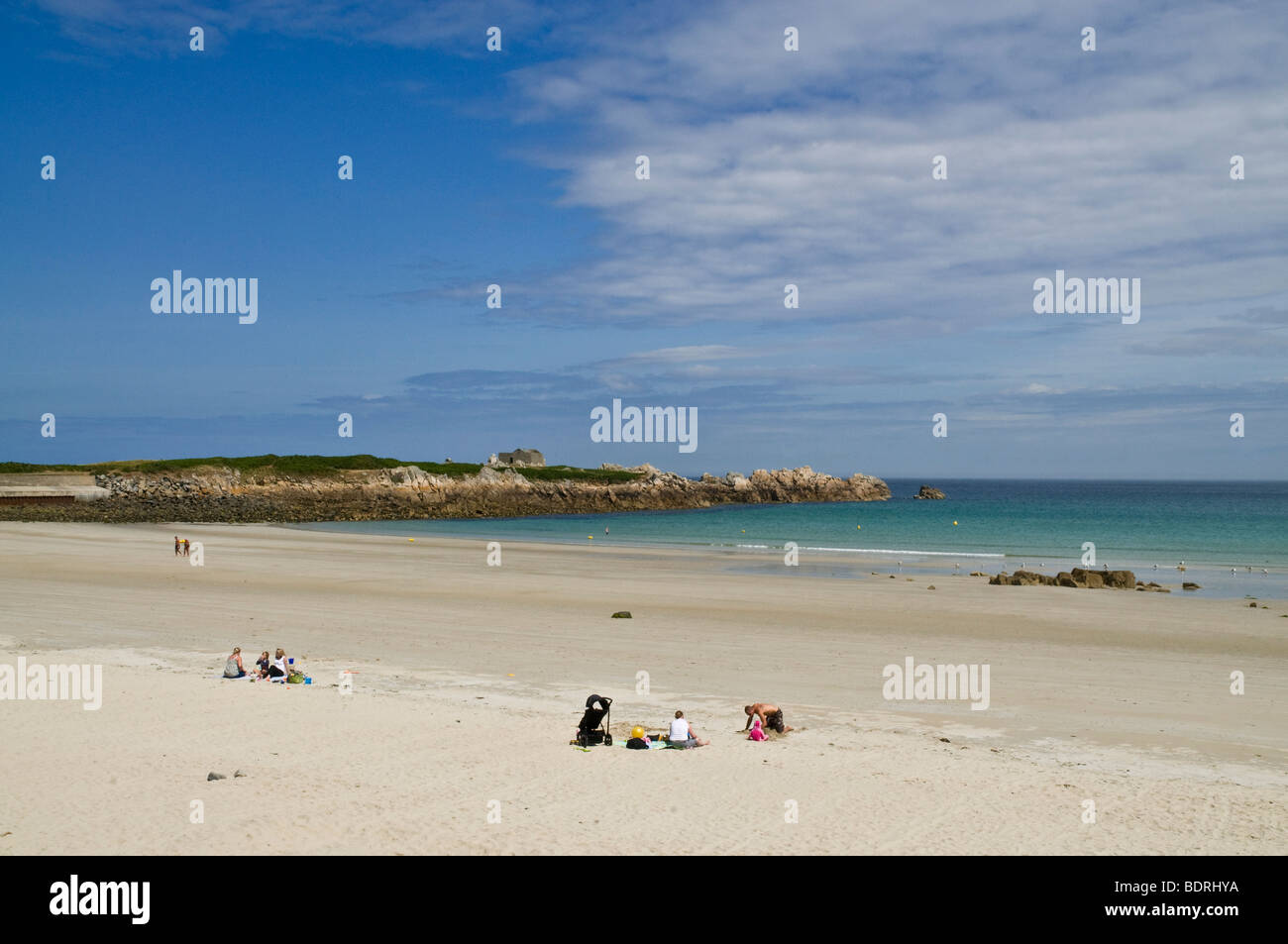 dh Pembroke Bay VALE GUERNSEY Families sitting on sandy beach LAncresse Bay holiday family summer sunshine Stock Photo