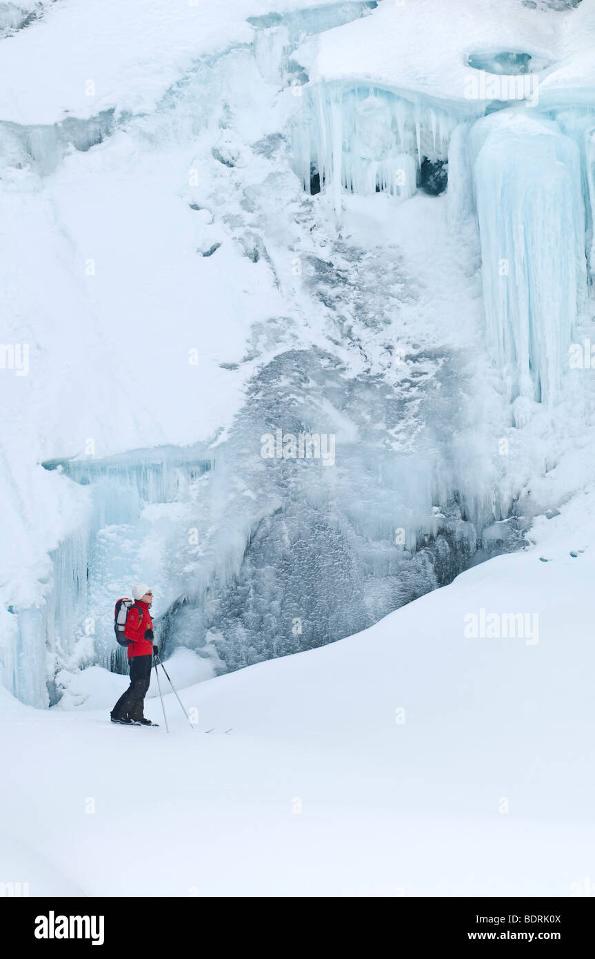 female skier in front of a frozen waterfall in padjelanta national park, swedish lapland Stock Photo