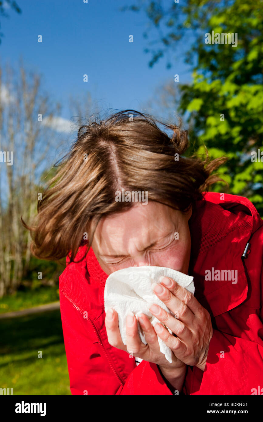 Woman sneezing in a tissue from a allergic reaction, Stock Photo