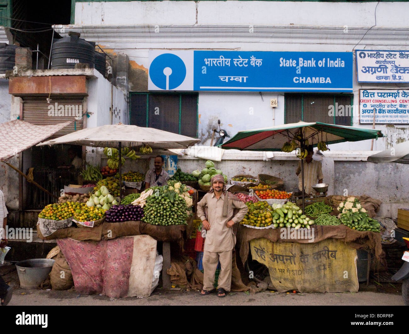 A fruit and vegetable stall in front of the State Bank of India branch in Chamba. Chamba, Himachal Pradesh. India. Stock Photo