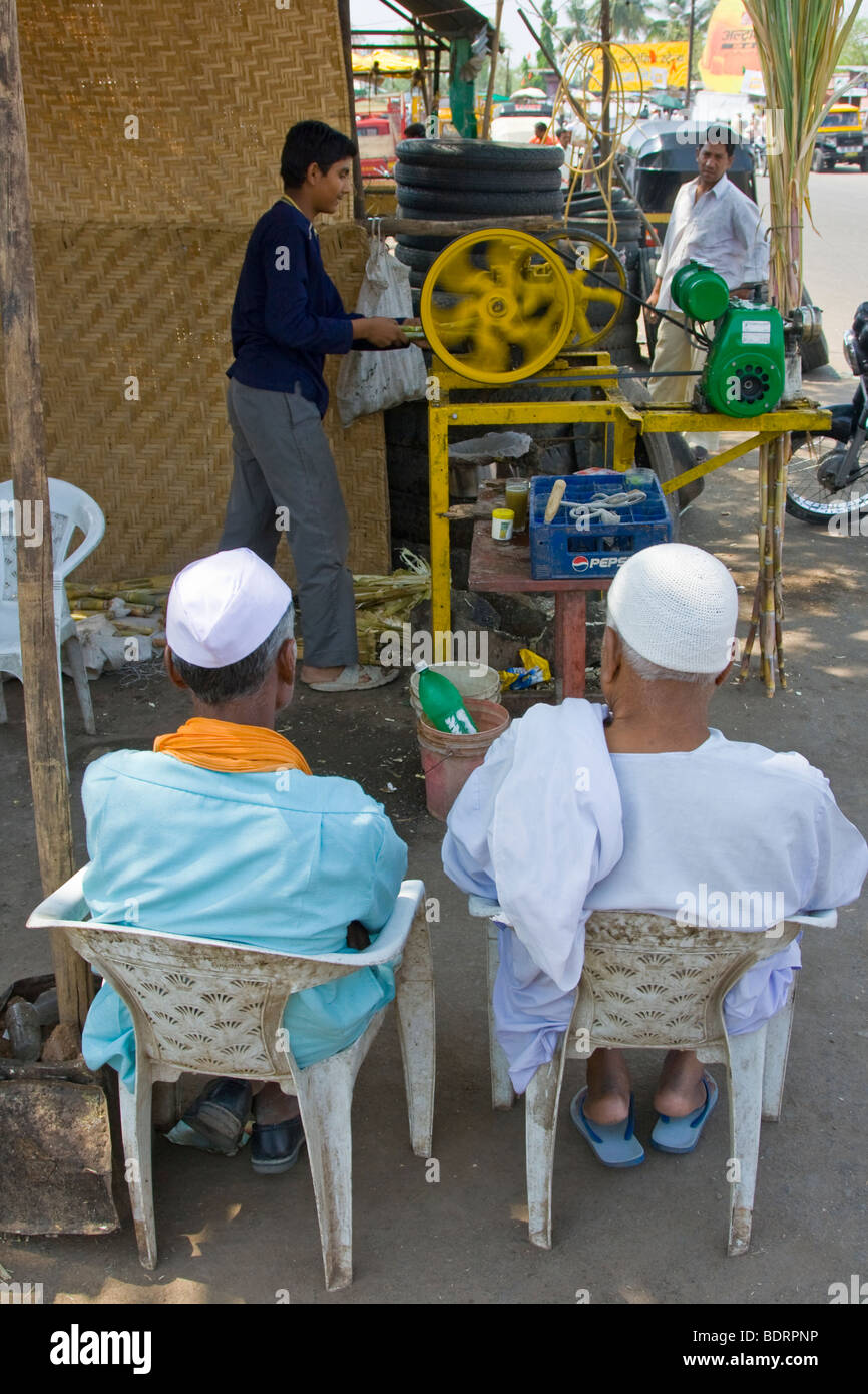 Muslim men wait for their fresh squeezed sugarcane juice in Daulatabad near Aurangabad India Stock Photo