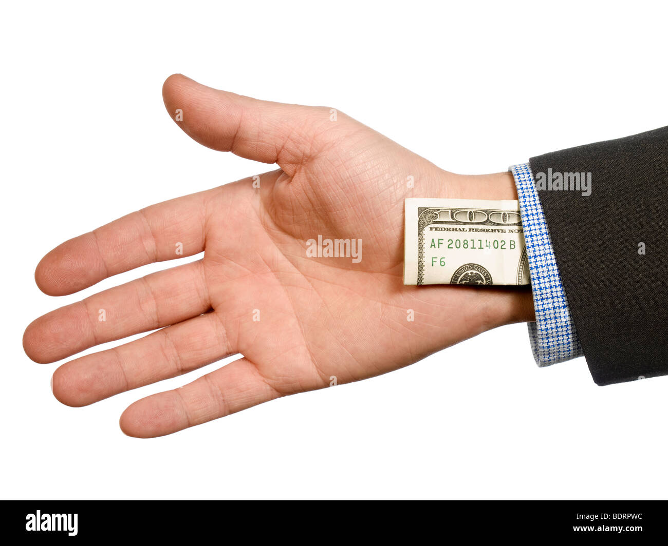 A man's hand hiding a one hundred dollar bill up his sleeve. Stock Photo