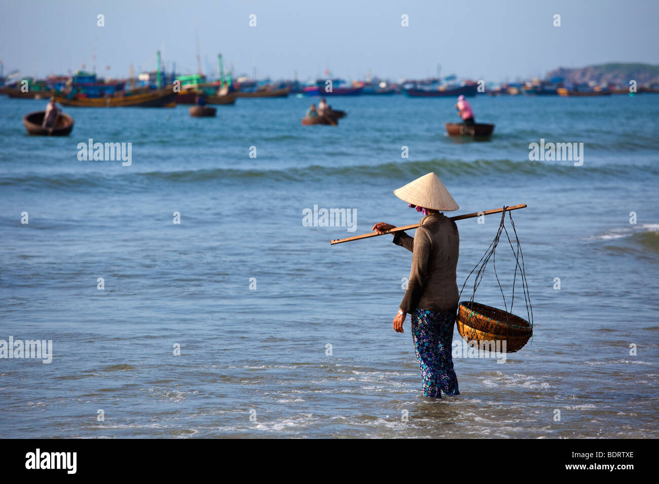 Vietnamese women awaiting for there husbands and their fishing catch for the day Stock Photo