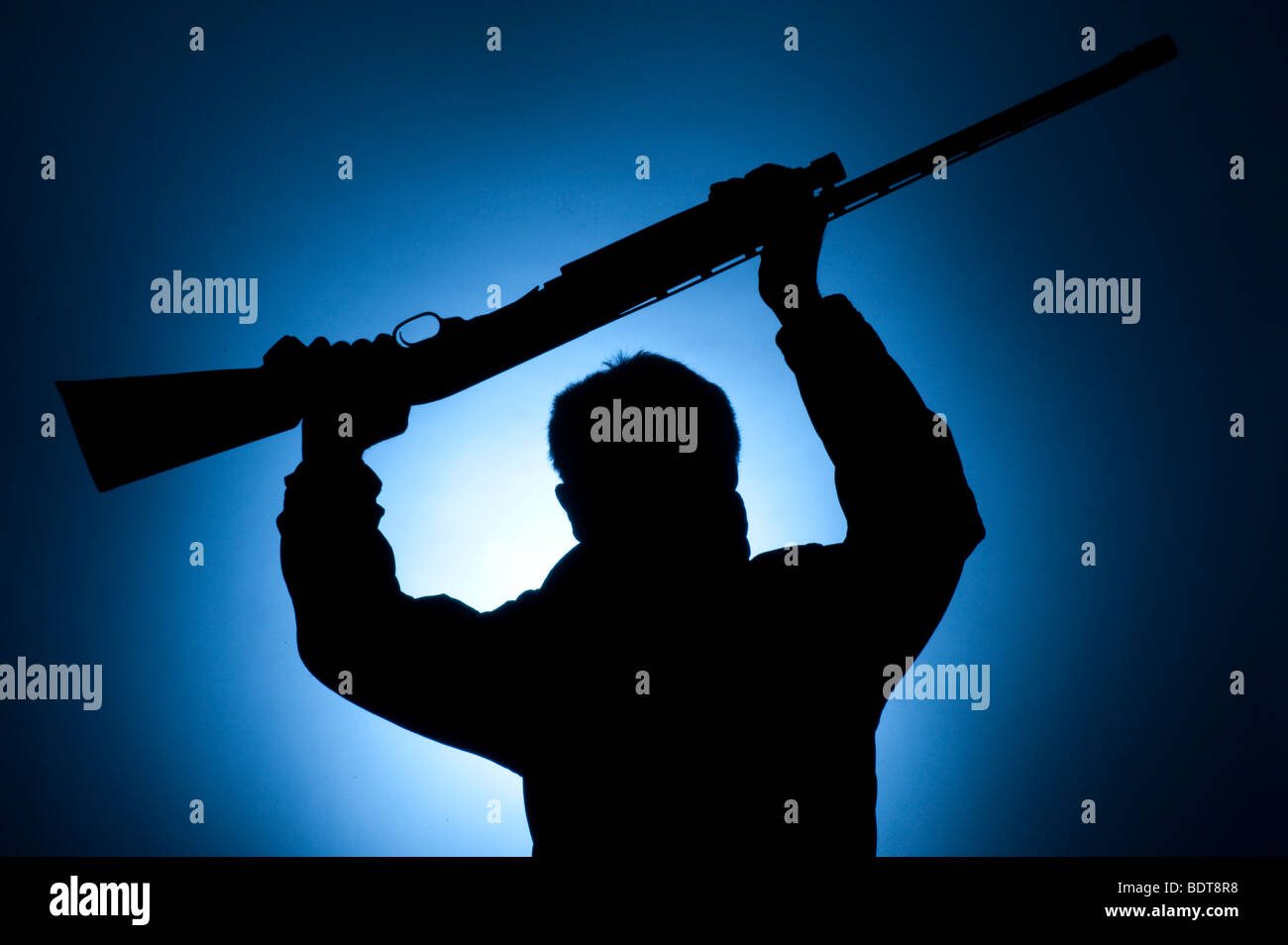 male terrorist wearing mask charging with large shotgun Stock Photo