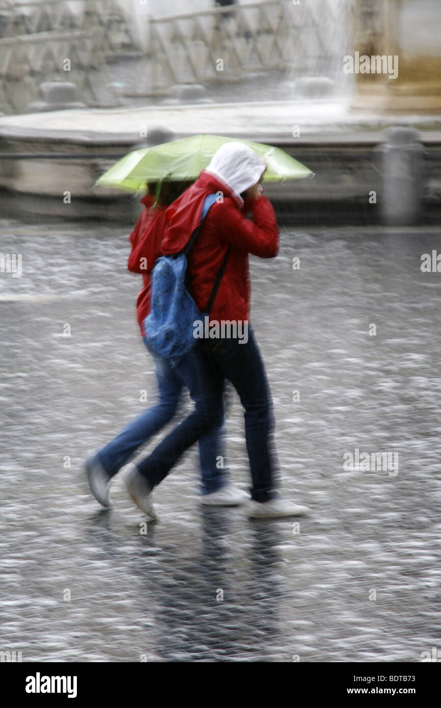 young couple sharing an umbrella in heavy rain Stock Photo - Alamy