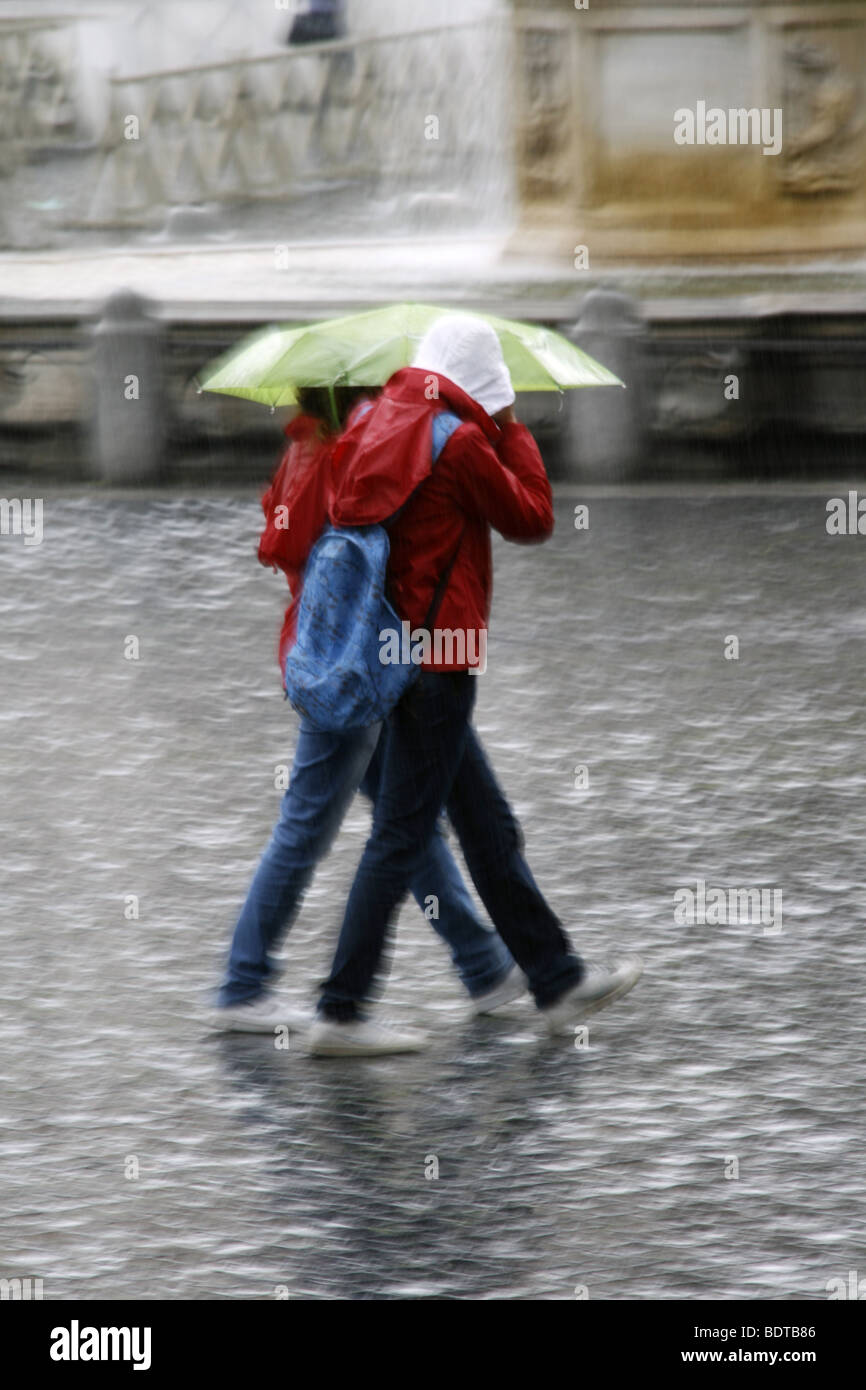 young couple sharing an umbrella in heavy rain Stock Photo - Alamy