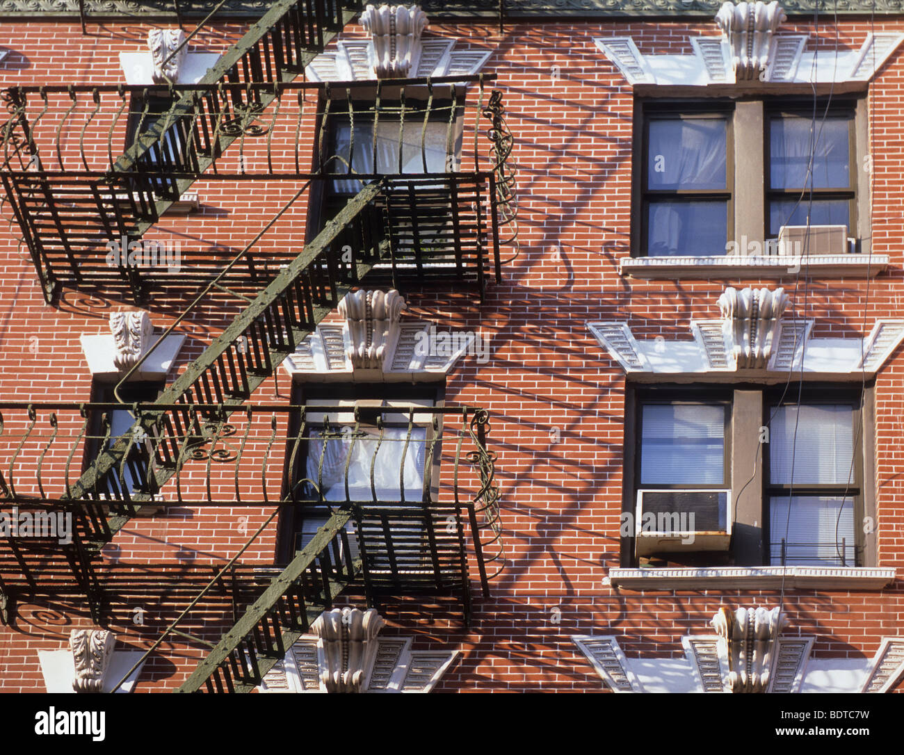 Residential tenement building with fire escapes in New York City. Red brick apartment house built in 19th century. Lower East Side Manhattan USA Stock Photo