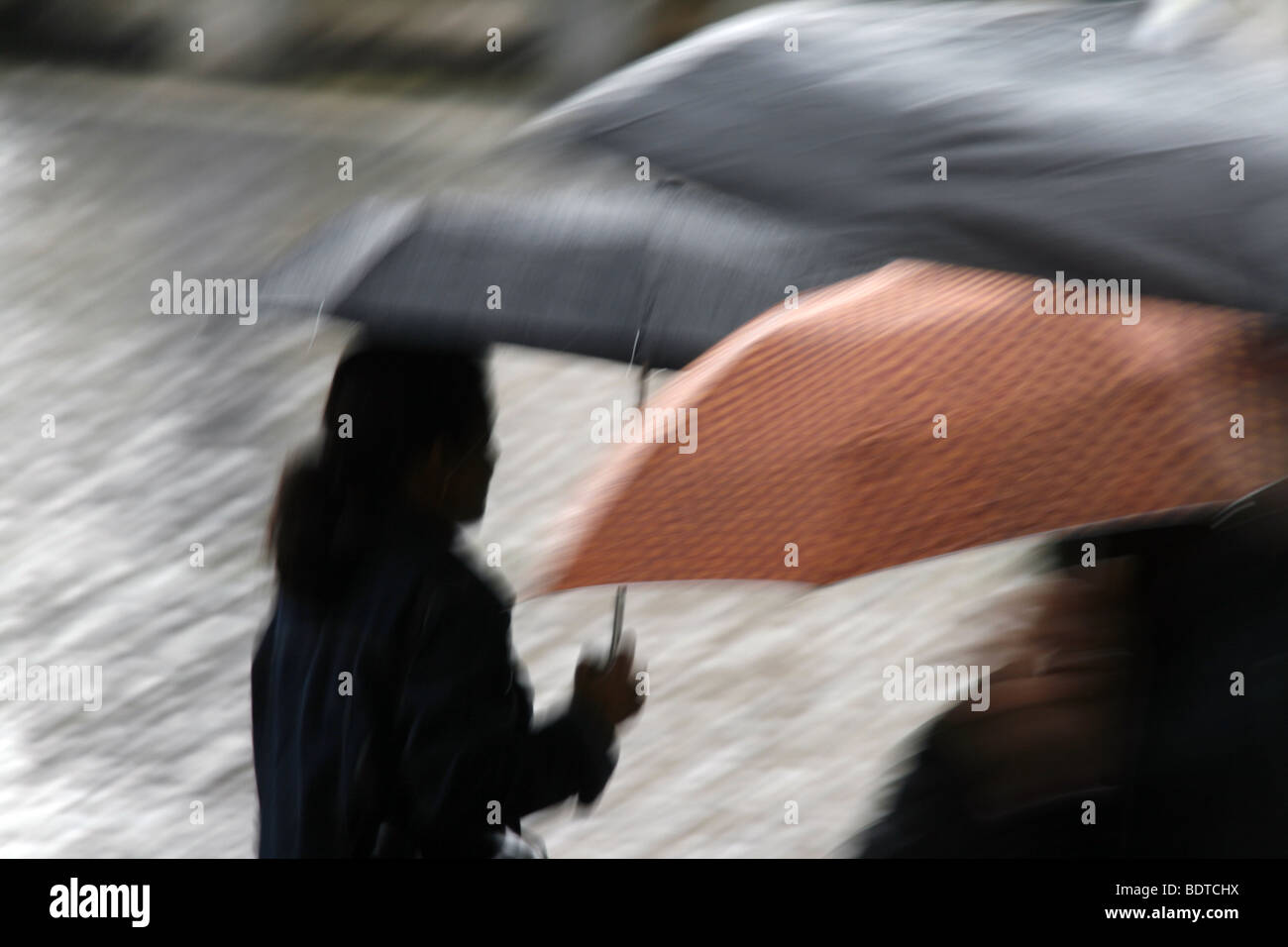 person walking with umbrella in city town Stock Photo - Alamy