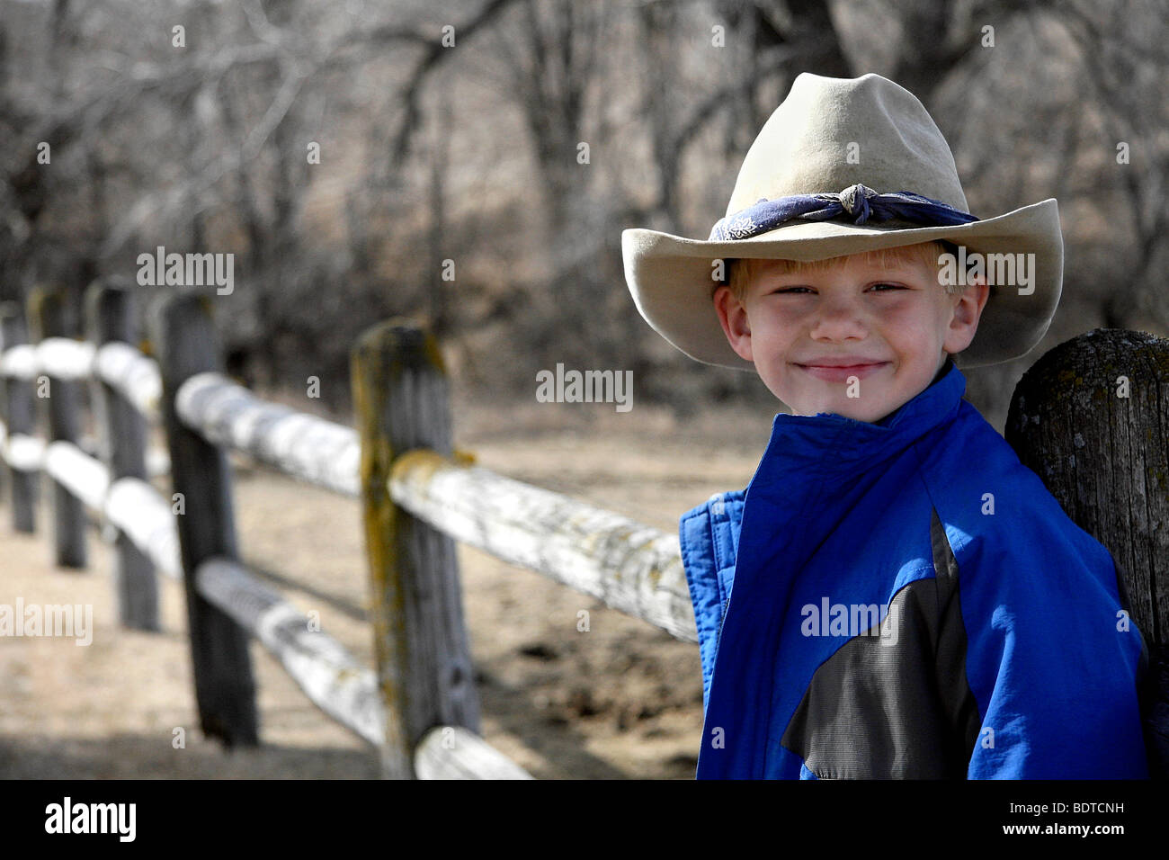 Young cowboy - smiling boy in western or cowboy hat on ranch along fence  line Stock Photo - Alamy