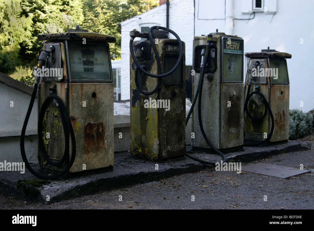 Defunct petrol pumps on garage forecourt Stock Photo