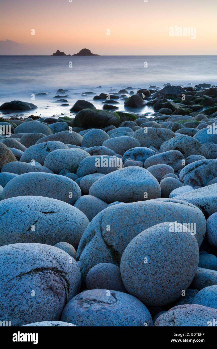 Circular boulders at Porth Nanven beach, with The Brisons island on the horizon, Cornwall, England. Spring (May) 2006 Stock Photo