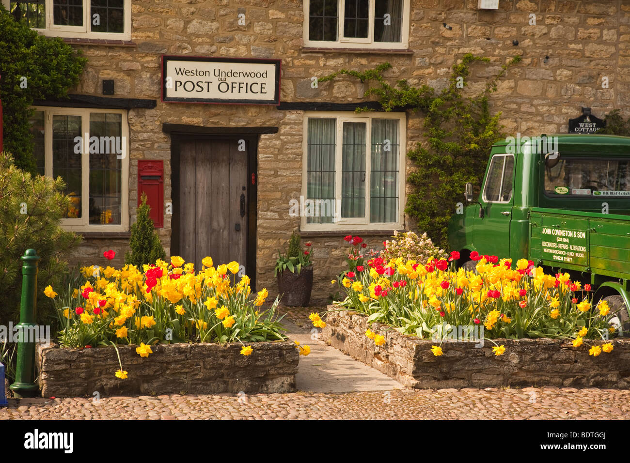Old English county post office in the village of Weston Underwood with post box, telephone booth and old van Stock Photo