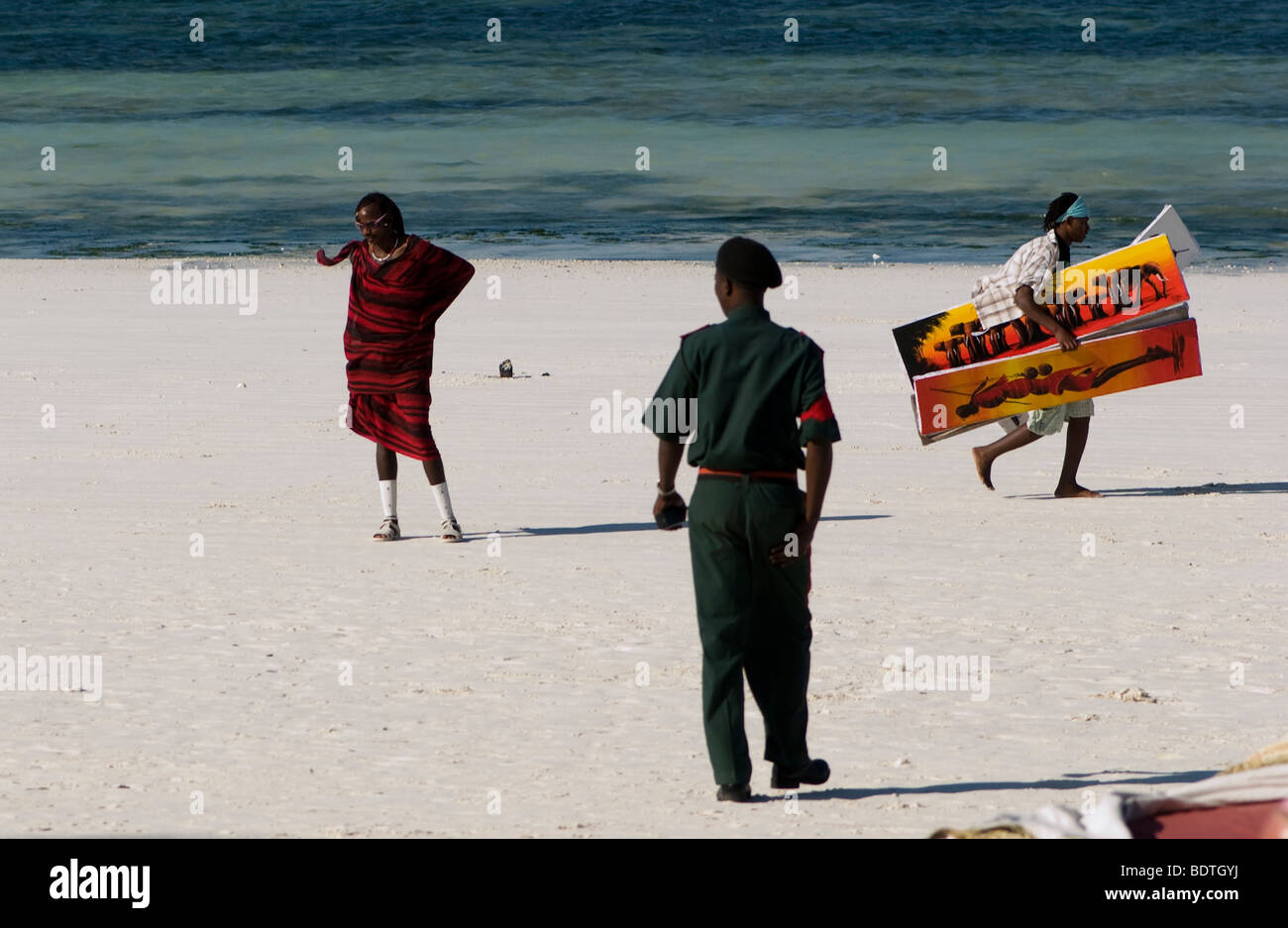 Masai walking on the beach with policeman Stock Photo