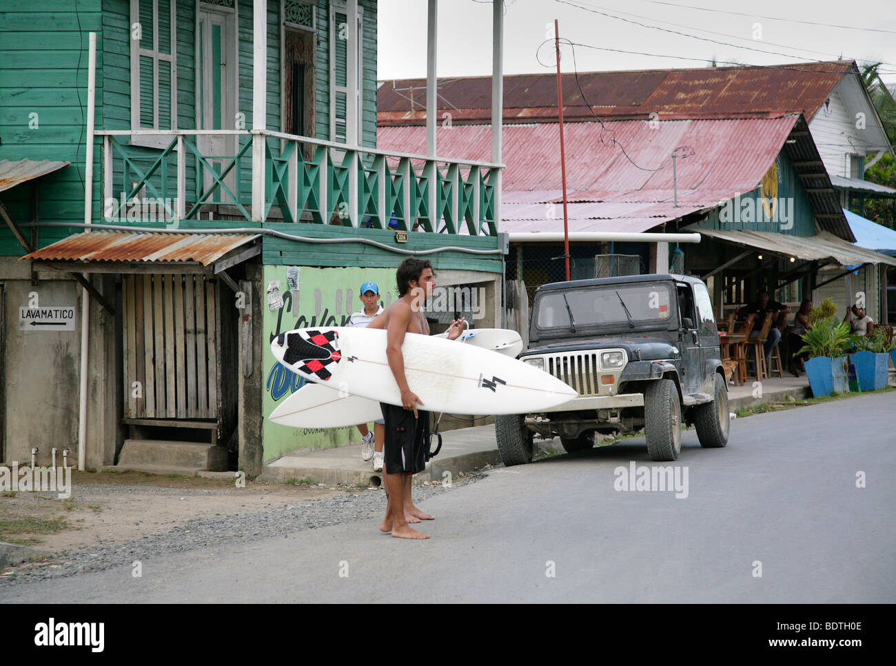 panama, bocas del toro, surfer tourist people walking with surfbords along the street in bocas town Stock Photo