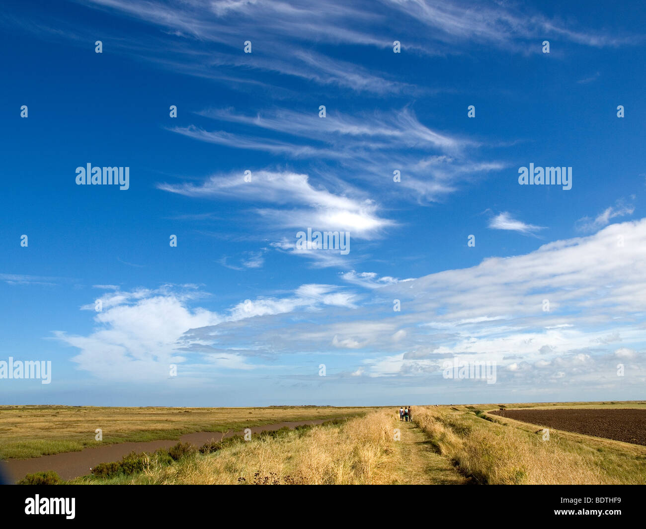 Huge sky where tourists walk over Peddars Way on the Norfolk Coast Path near Brancaster Staithe Stock Photo