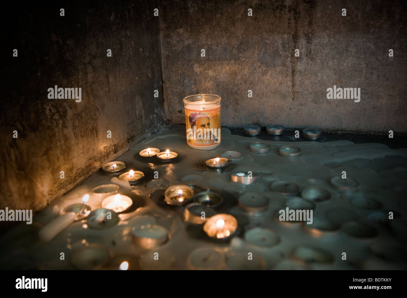 A burning candle bears the figure of Jewish spiritual leader Rabbi Shimon Bar Yochai at his tomb