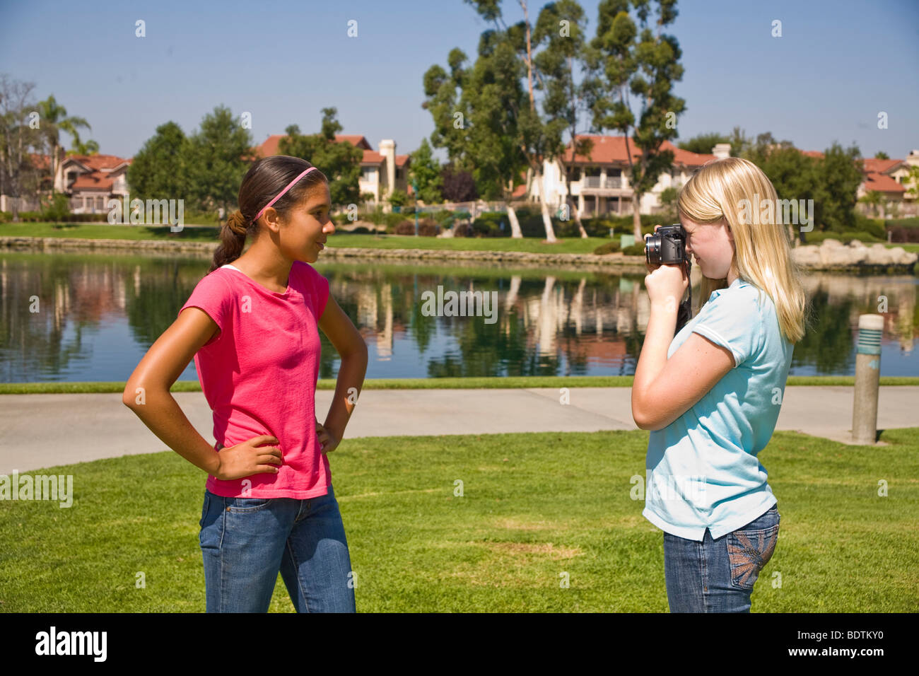 Caucasian junior high girl takes photo of her Hispanic friend.MR  © Myrleen Pearson Stock Photo