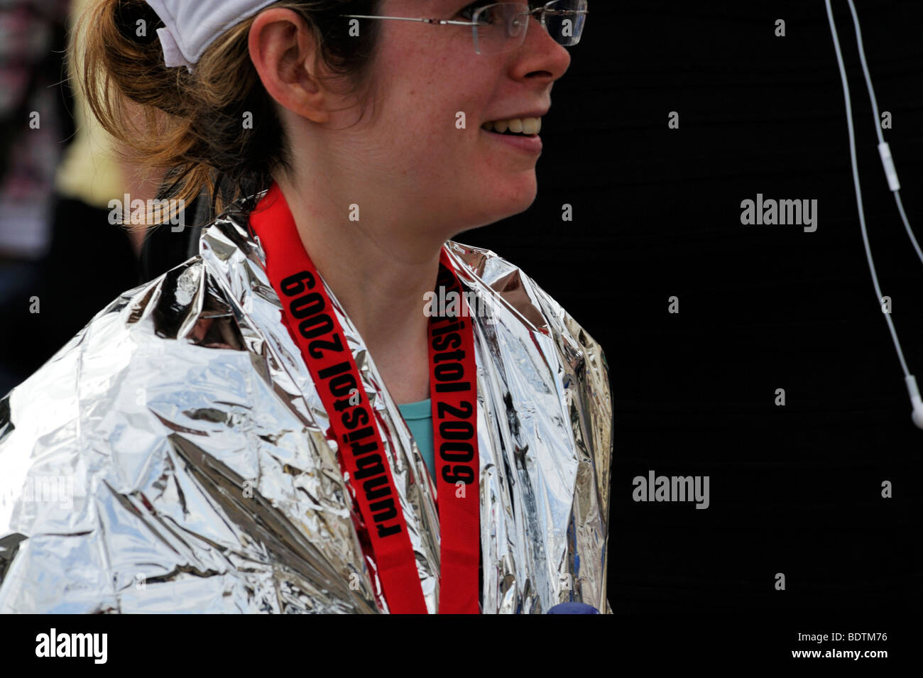 Young woman runner in foil wrap after Bristol Half Marathon, UK Stock Photo