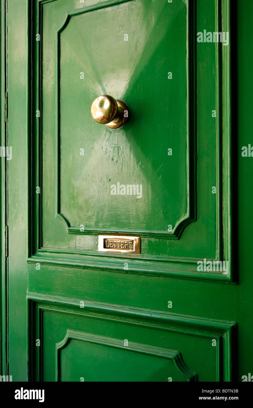 Green door with brass handle and letter box. Stock Photo