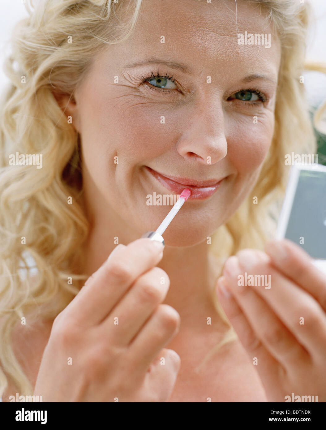 Woman using lip gloss Stock Photo