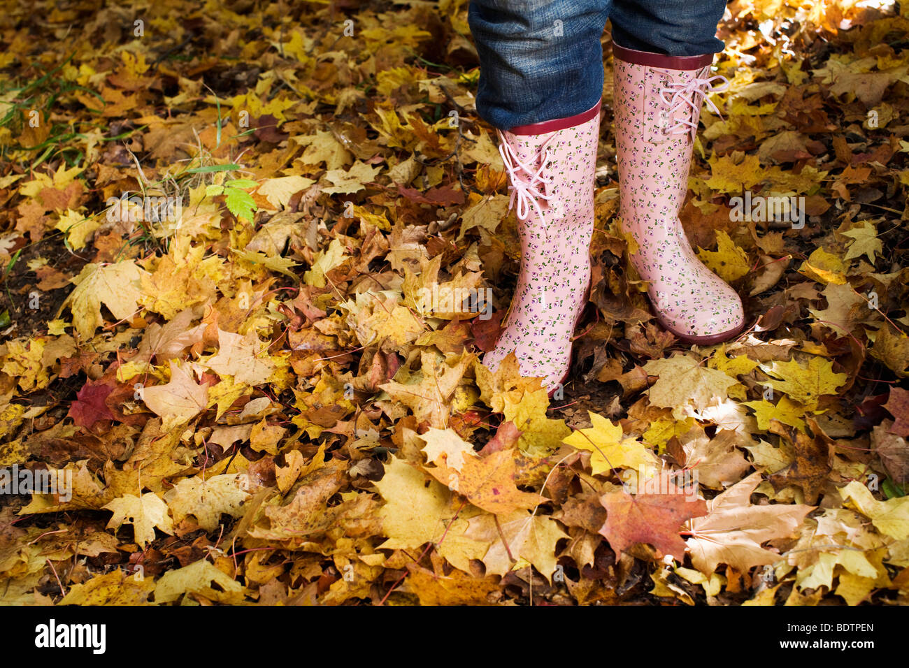 A woman wearing rubber boats in autumn forest Stock Photo