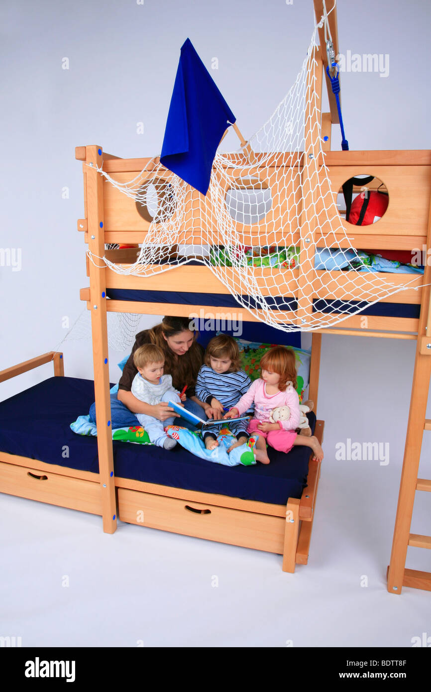 mother reading a book to her children in a Billi-Bolli loft bed Stock Photo
