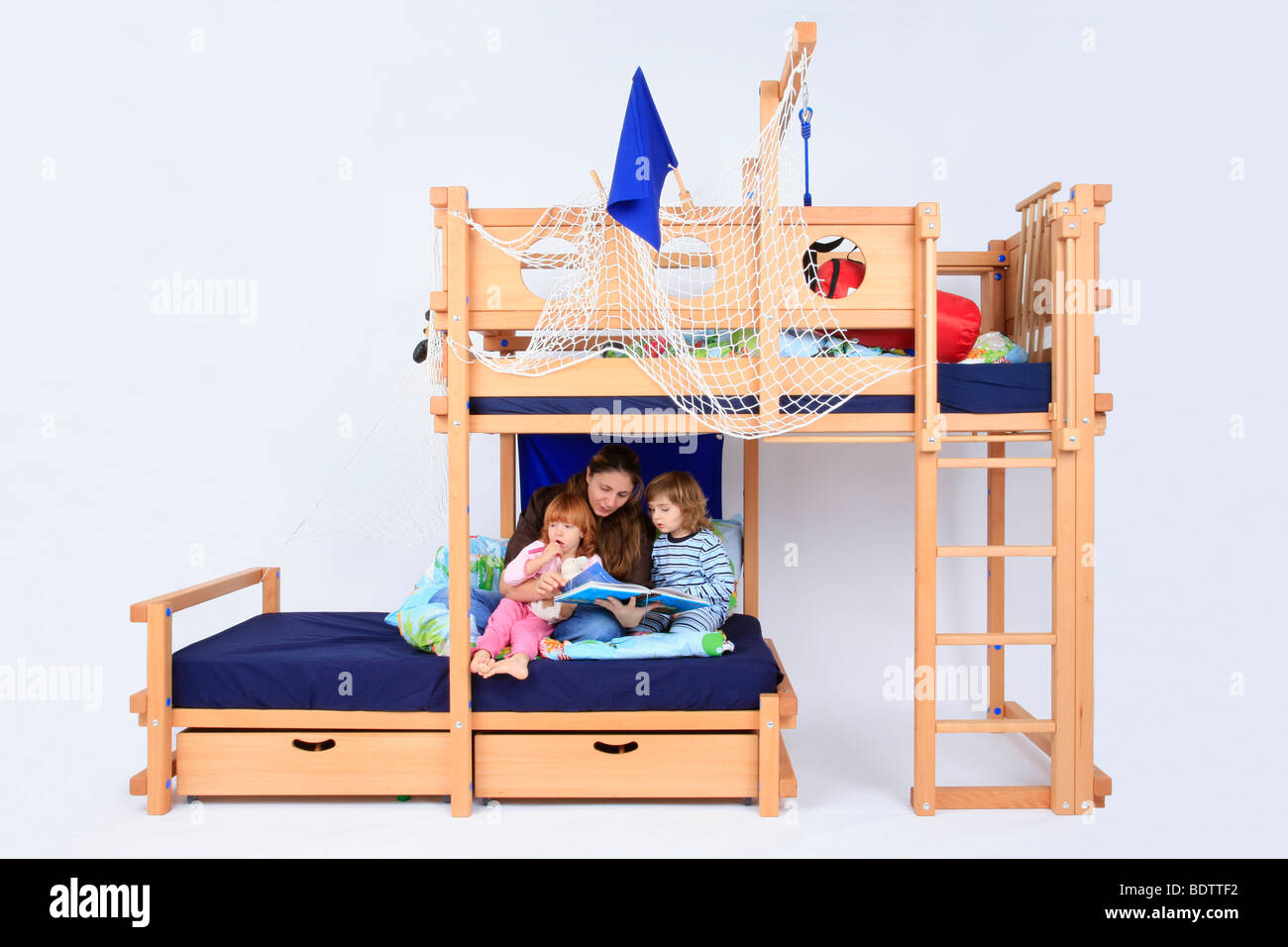 mother reading a book to her children in a Billi-Bolli loft bed Stock Photo