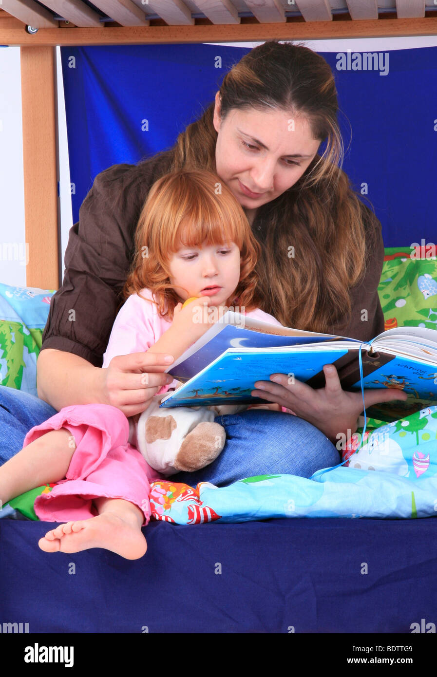 mother reading a book to her daugter in a Billi-Bolli loft bed Stock Photo