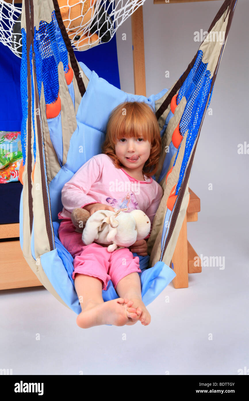 little girl in a swing of a Billi-Bolli loft bed Stock Photo