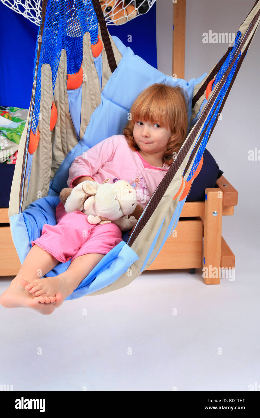 little girl in a swing of a Billi-Bolli loft bed Stock Photo