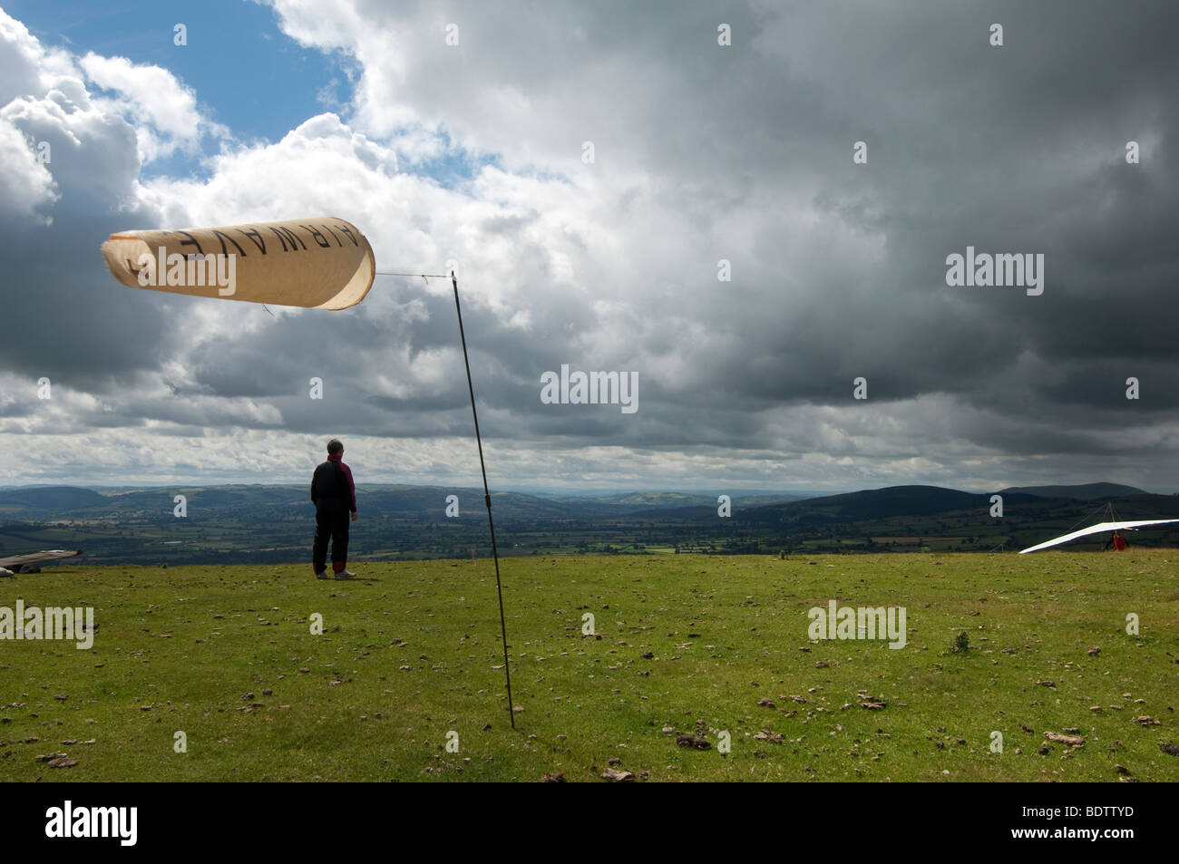 wind sock on hill with hang gliders Stock Photo