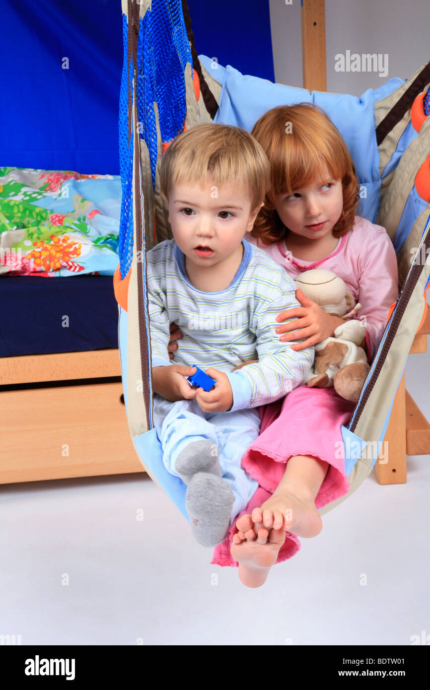 little girl and littel boy in a swing of a Billi-Bolli loft bed Stock Photo