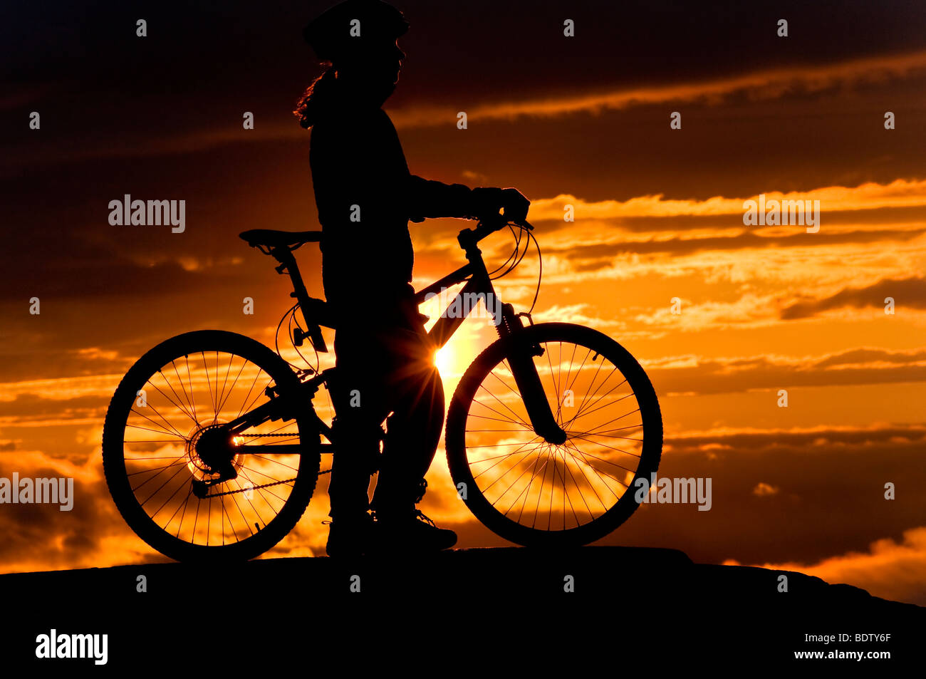 female downhill cyclist at midnight sun, lapland, sweden Stock Photo