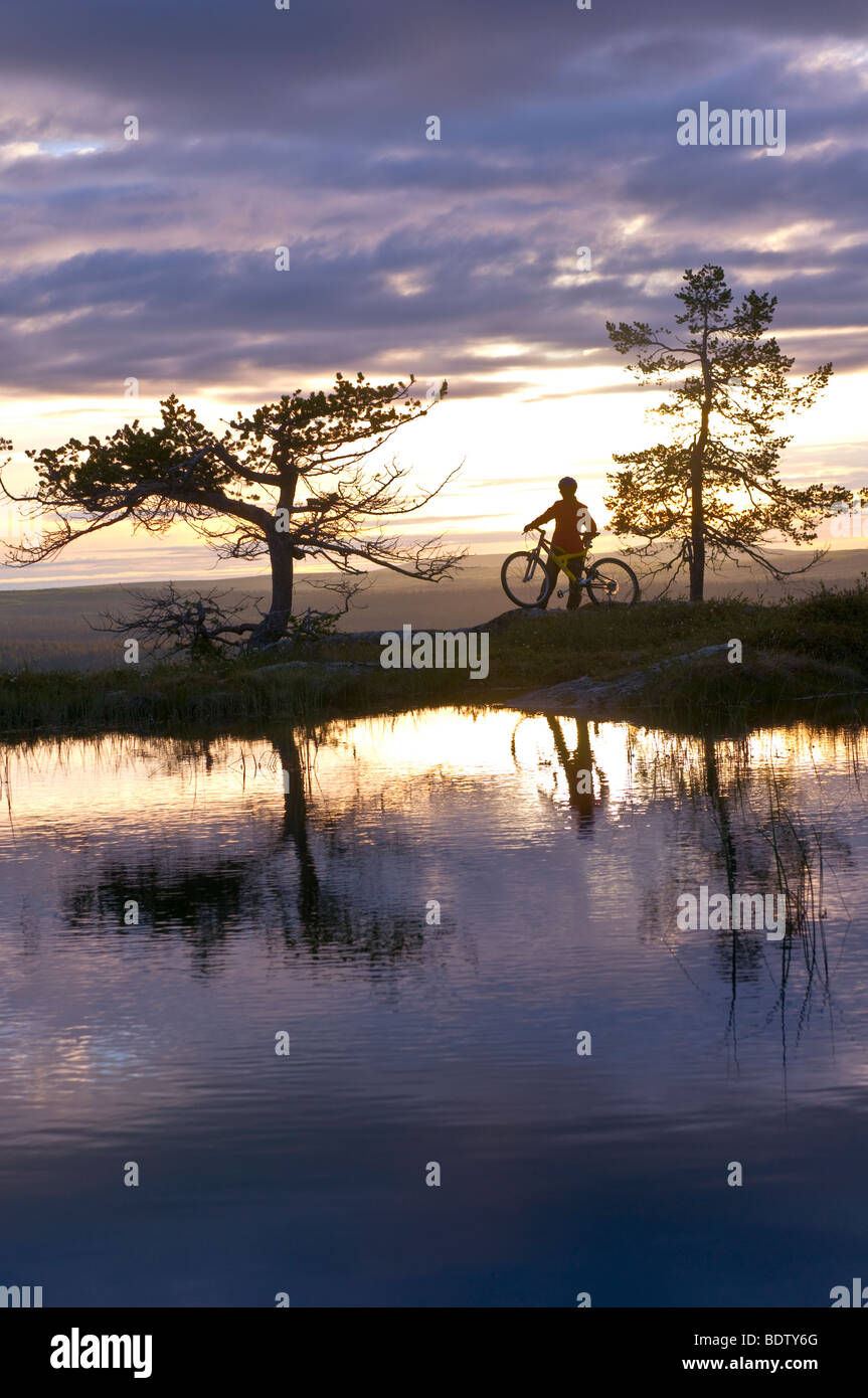 mountainbikerin an einem bergsee in gaellivare, lappland, schweden, downhill cyclist at a mountain lake in lapland, sweden Stock Photo