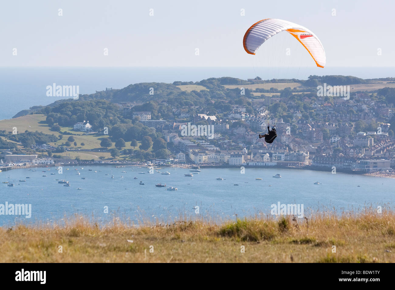 Paraglider on Ballard Down above Swanage Bay, Dorset, UK Stock Photo