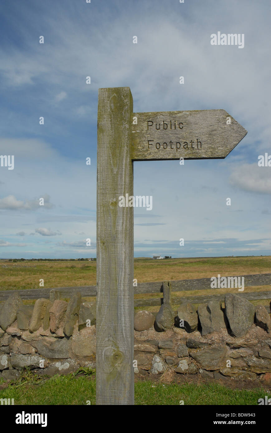 Wooden sign pointing in the direction of a public footpath. Copyright