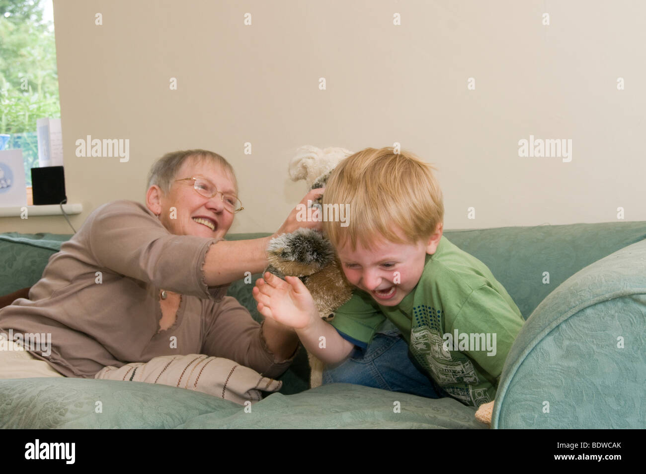 Grandmother and grandson playing with cuddly toy Stock Photo