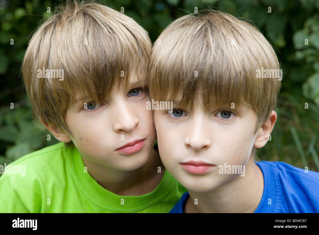 serious twins hugging in park Stock Photo - Alamy