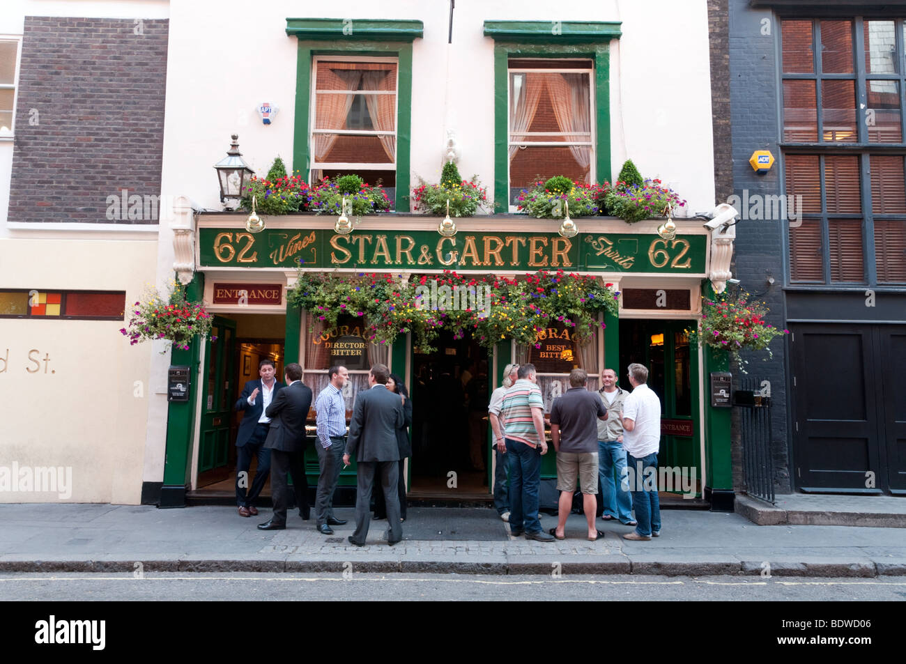 People drinking outside the Star and Garter pub in Poland Street in Soho, London, England, UK