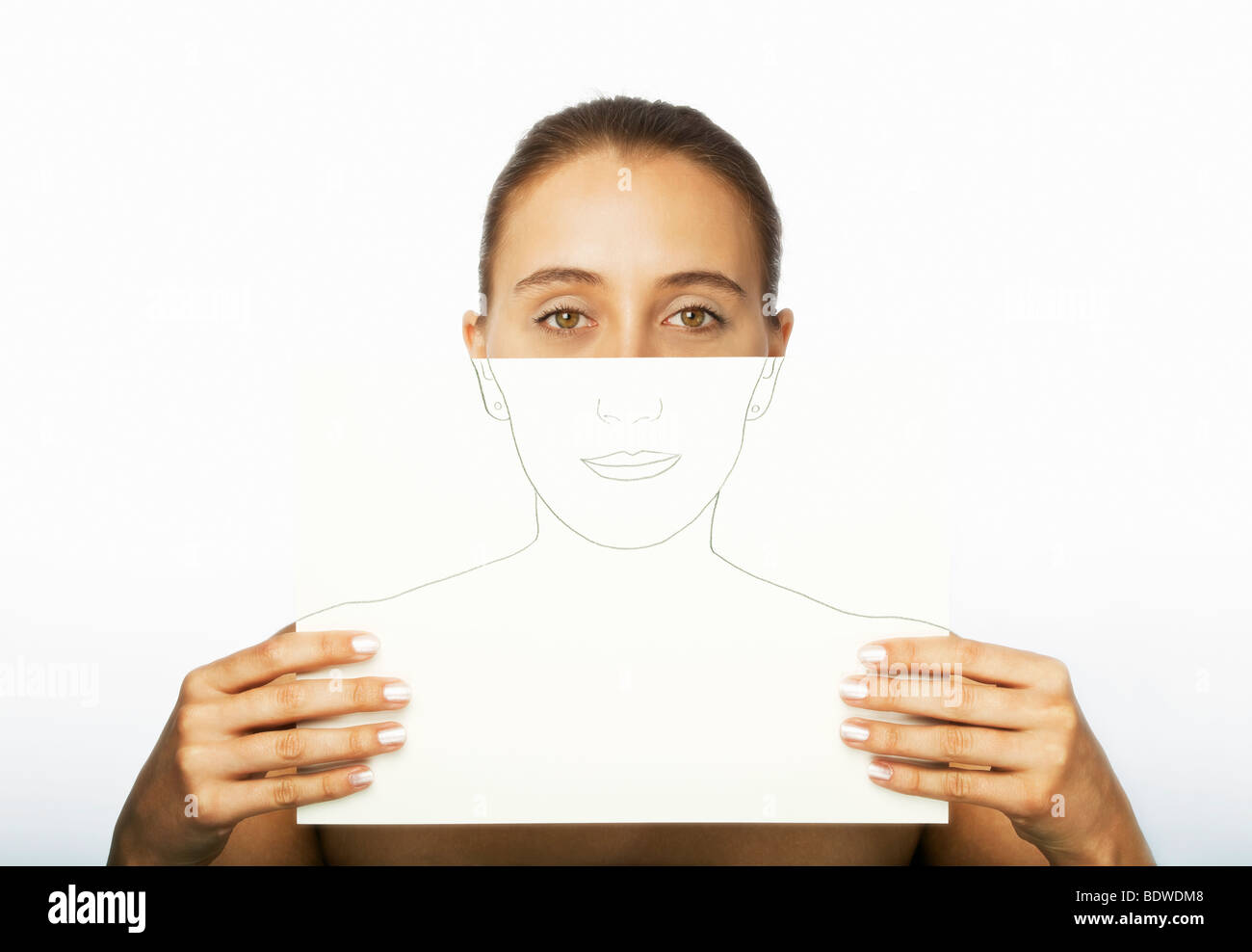 Young woman holding a drawn portrait of herself Stock Photo