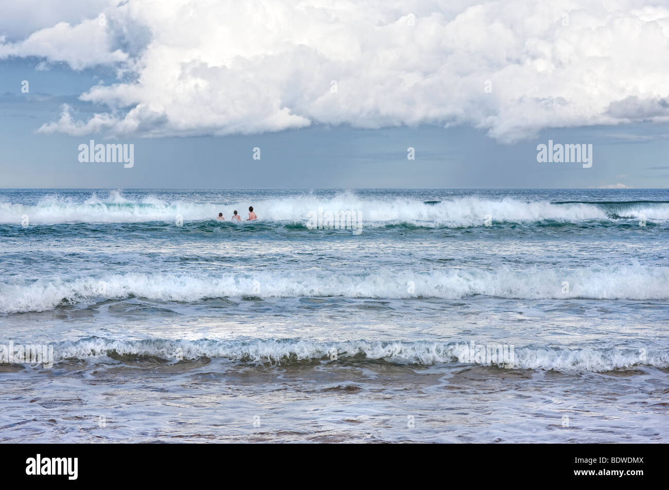 Three young people brave the cold North Sea during a British summer Stock Photo