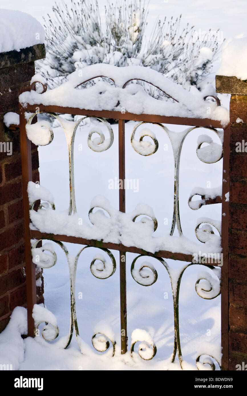 Snow covered rusty wrought iron gate Stock Photo