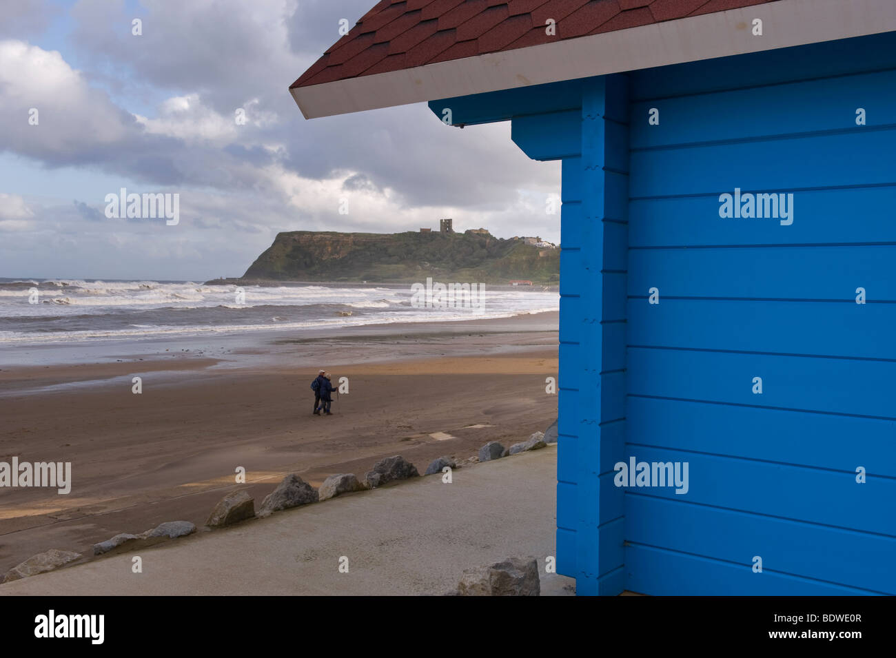 People walking on the beach, North Bay, Scarborough, towards the castle on the headland. Stock Photo