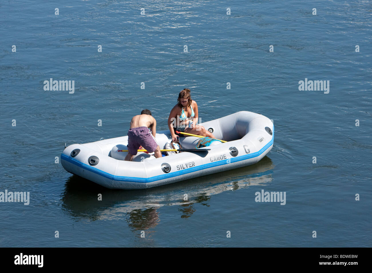 A young couple out for the day on the Delaware River. Floating down the river in a rubber boat. Stock Photo